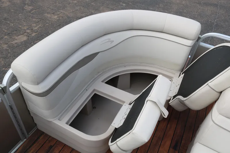 Slide: The Image of 2015 Bennington 22SSLDX pontoon boat with white cushioned seating and storage compartment. - 13