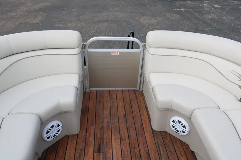 Slide: The Image of 2015 Bennington 22SSLDX boat interior with beige seating and wood flooring. - 16