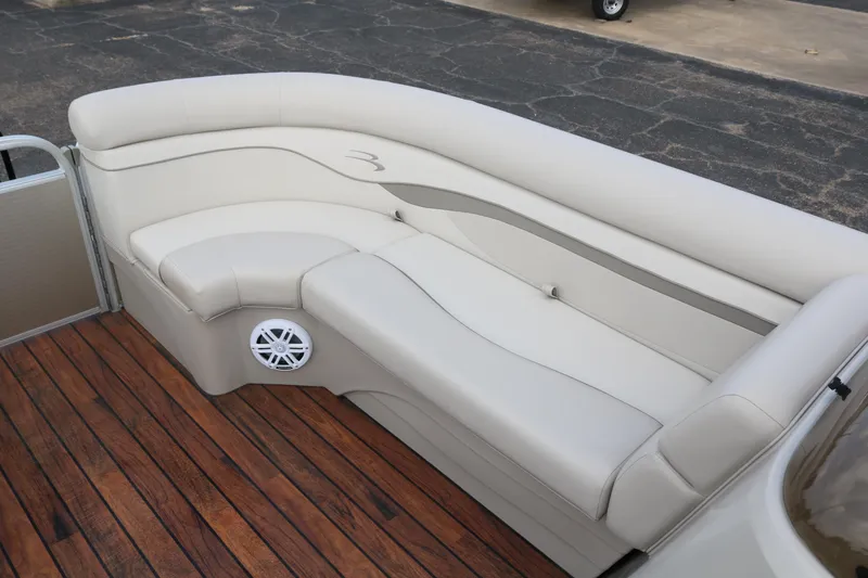 Slide: The Image of 2015 Bennington 22SSLDX boat interior with beige seating and wood flooring. - 17