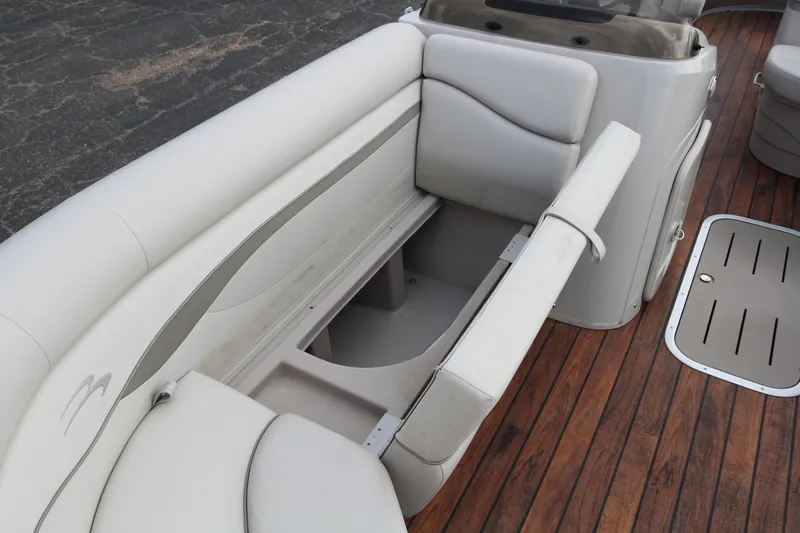 Slide: The Image of 2015 Bennington 22SSLDX boat interior with open storage compartment and wooden deck. - 21