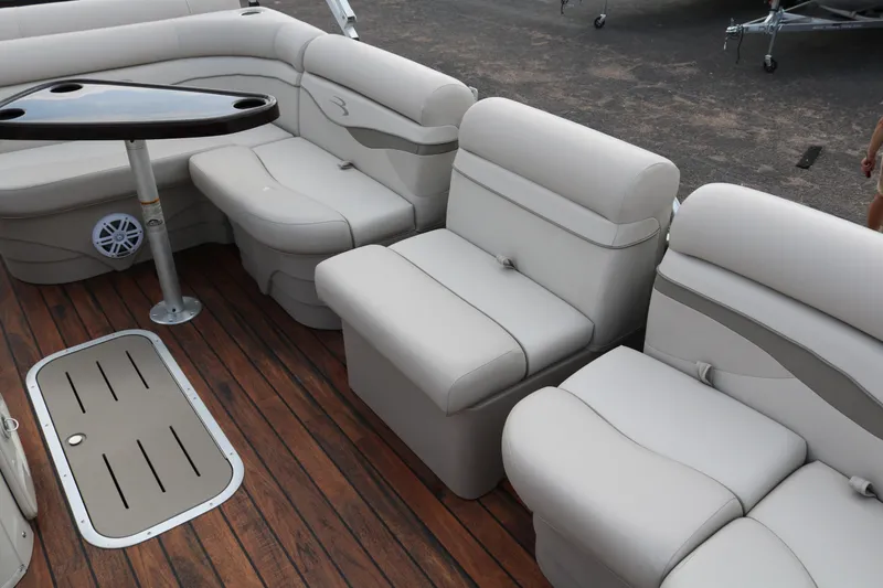 Slide: The Image of 2015 Bennington 22SSLDX pontoon boat interior with plush seating and wood-style flooring. - 22