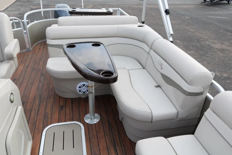 Slide: The Image of Luxurious seating area on 2015 Bennington 22SSLDX pontoon boat with wood flooring and table. - 23