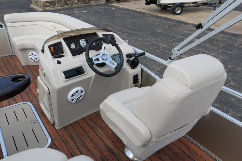 Slide: The Image of 2015 Bennington 22SSLDX boat interior with steering console and beige seating. - 27