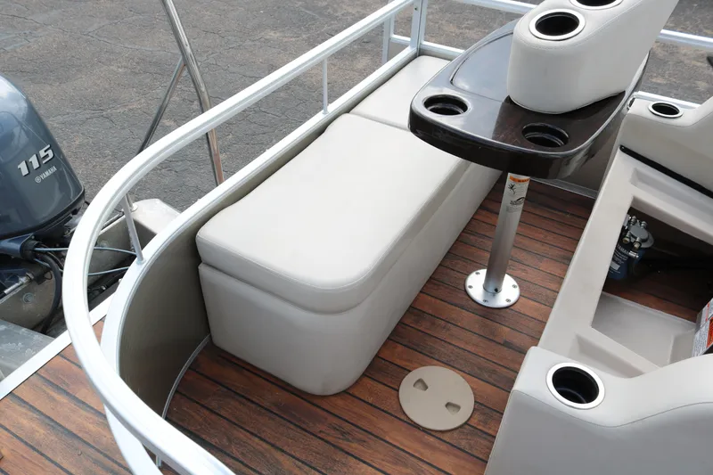 Slide: The Image of 2015 Bennington 22SSLDX boat interior with seating and table on wooden deck. - 32