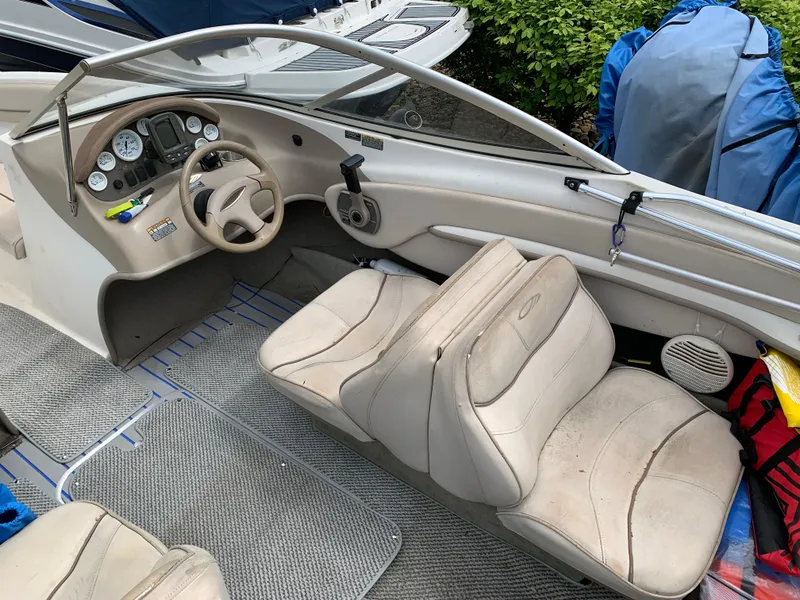 Slide: The Image of 2001 Maxum 1800 SR boat interior with beige seating and dashboard controls. - 5