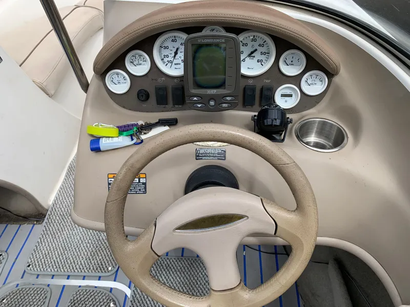 Slide: The Image of 2001 Maxum 1800 SR boat dashboard with gauges, steering wheel, and cup holder. - 6
