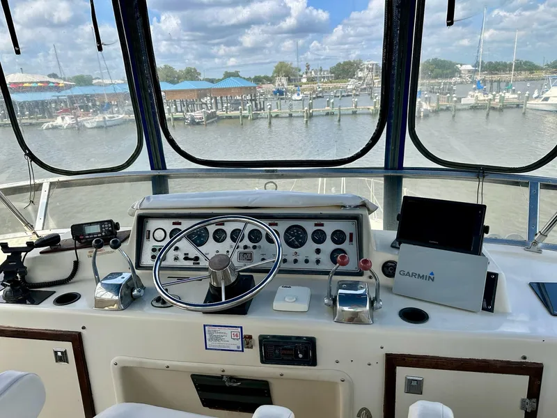 Slide: The Image of Helm of 1986 Chris-Craft Yacht Fisherman with navigation equipment and marina view. - 12