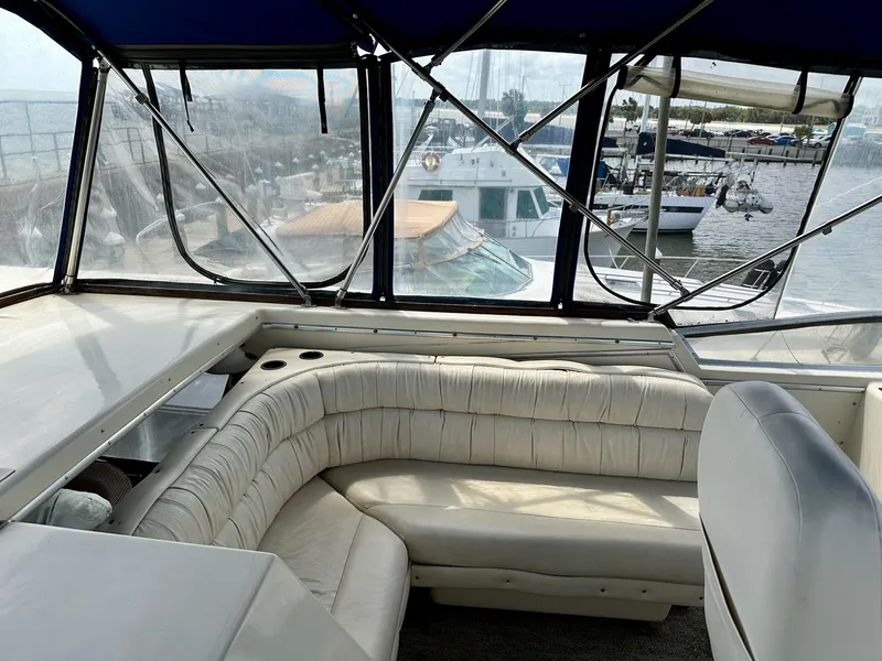 Slide: The Image of 1986 Chris-Craft Yacht Fisherman interior with white seating and marina view. - 13