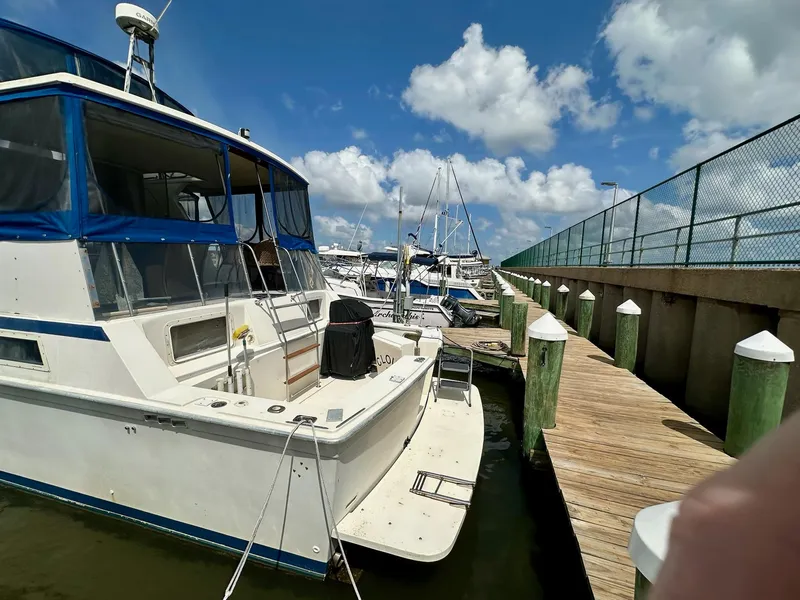 Slide: The Image of 1986 Chris-Craft Yacht Fisherman docked at marina under blue sky. - 2