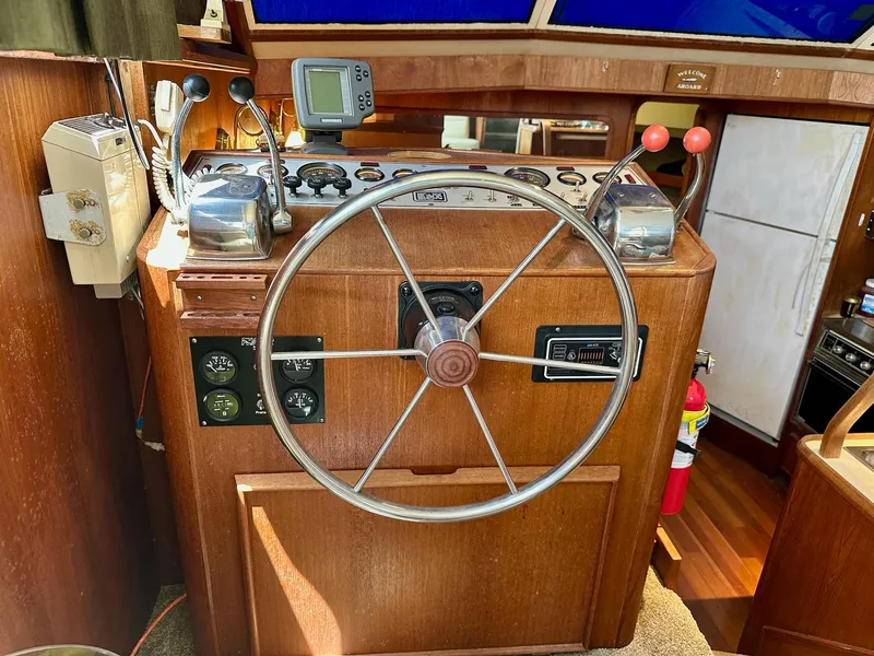 Slide: The Image of 1986 Chris-Craft Yacht Fisherman helm with wooden steering wheel and control panel. - 21