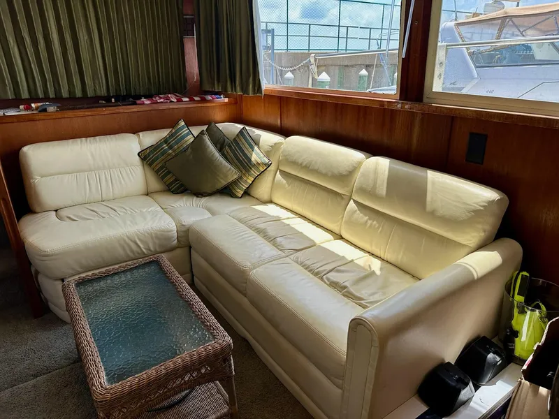 Slide: The Image of Luxurious interior of 1986 Chris-Craft Yacht Fisherman with cream leather sofa and glass-top table. - 22