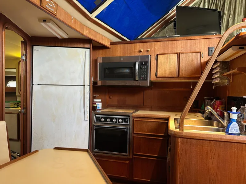 Slide: The Image of 1986 Chris-Craft Yacht Fisherman kitchen with wooden cabinetry, appliances, and a skylight. - 24