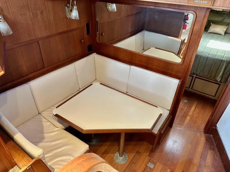 Slide: The Image of 1986 Chris-Craft Yacht Fisherman interior with wooden paneling and cushioned seating area. - 25