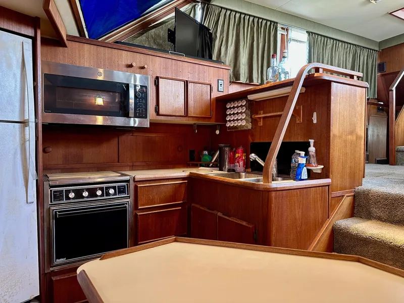 Slide: The Image of 1986 Chris-Craft Yacht Fisherman kitchen with wood cabinetry, microwave, and sink. - 26