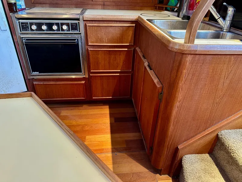 Slide: The Image of 1986 Chris-Craft Yacht Fisherman kitchen with wooden cabinets and stainless steel sink. - 27