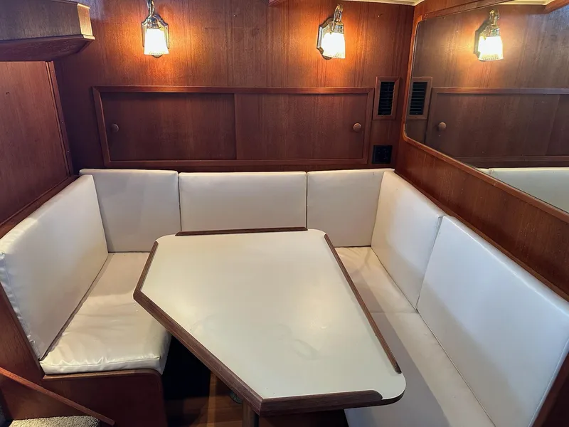 Slide: The Image of 1986 Chris-Craft Yacht Fisherman interior with wood paneling and white cushioned seating. - 28