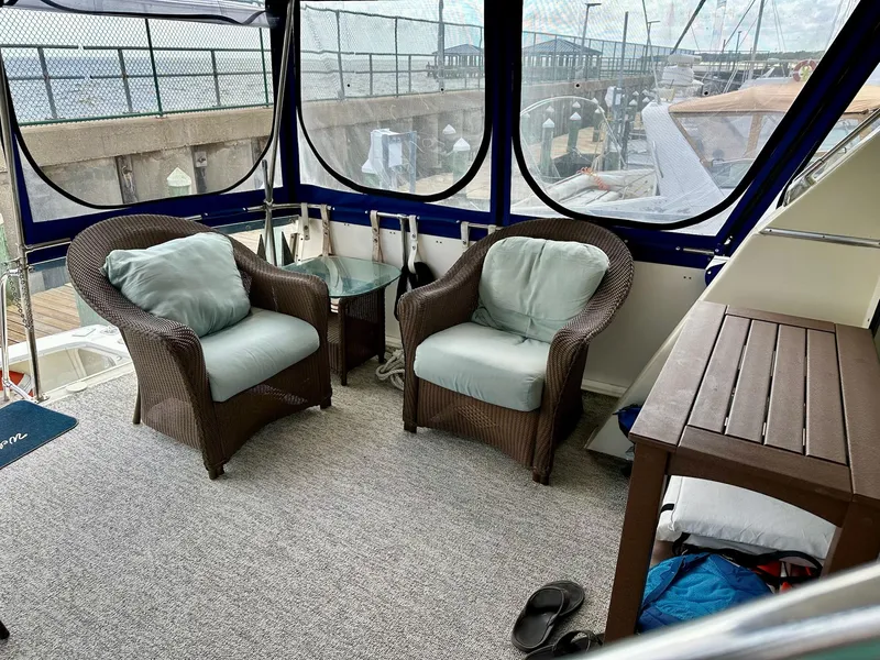 Slide: The Image of Cozy seating area on 1986 Chris-Craft Yacht Fisherman with wicker chairs and glass table. - 3