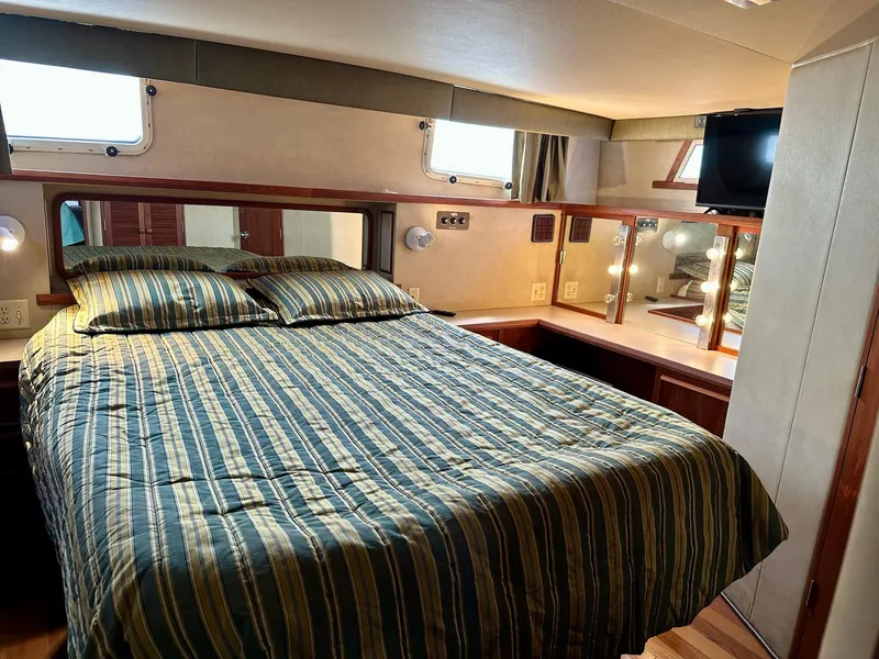 Slide: The Image of Luxurious bedroom in 1986 Chris-Craft Yacht Fisherman with striped bedding and vanity area. - 35