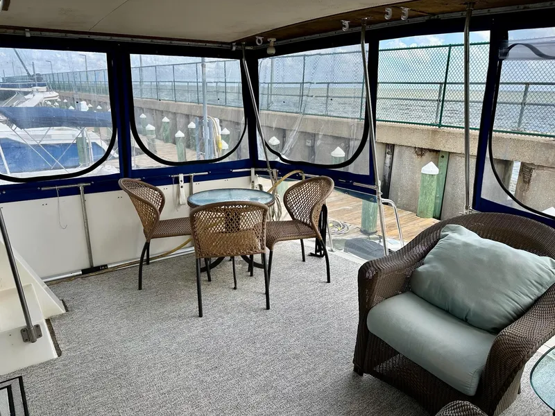 Slide: The Image of 1986 Chris-Craft Yacht Fisherman interior with wicker furniture and marina view. - 5