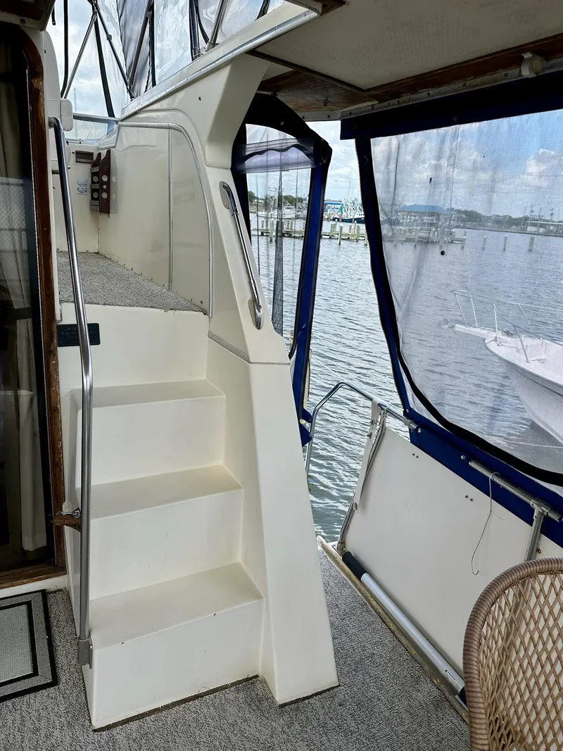 Slide: The Image of 1986 Chris-Craft Yacht Fisherman interior with stairs and marina view. - 6