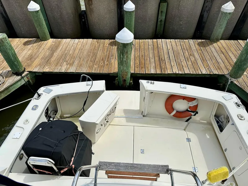 Slide: The Image of 1986 Chris-Craft Yacht Fisherman docked, featuring a spacious deck and safety equipment. - 7