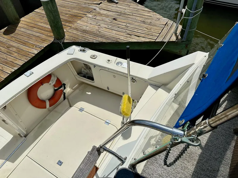 Slide: The Image of 1986 Chris-Craft Yacht Fisherman docked, featuring deck area with life preserver and cleaning brush. - 9