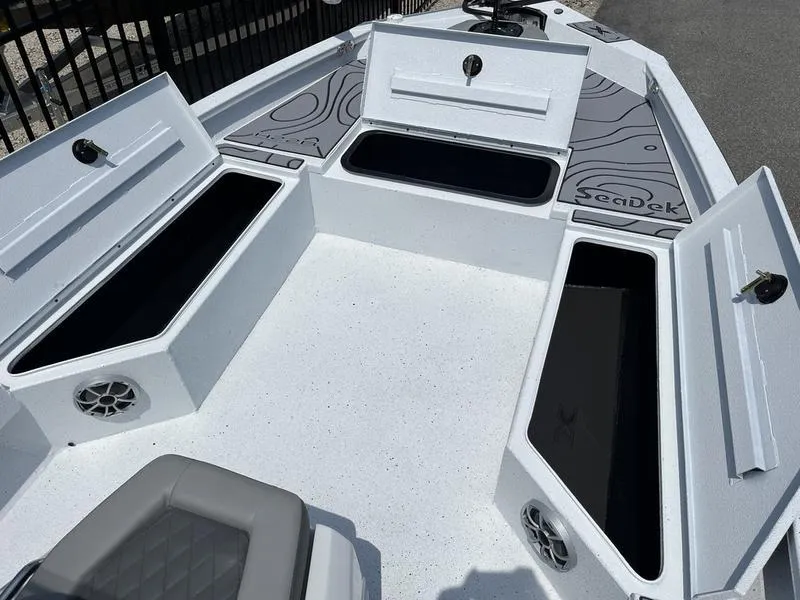 Slide: The Image of 2025 Xpress H22B boat with open storage compartments and SeaDek flooring. - 6
