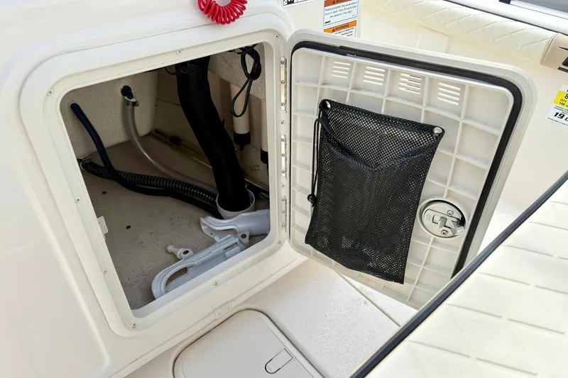 Slide: The Image of 2024 Carolina Skiff 19 LS storage compartment with open hatch and netted pocket. - 22