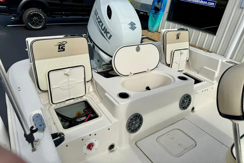 Slide: The Image of 2024 Carolina Skiff 19 LS boat interior with Suzuki engine, storage compartments, and seating. - 31