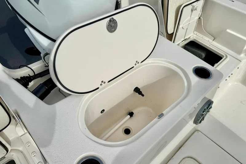 Slide: The Image of 2024 Carolina Skiff 19 LS boat with open storage compartment and cup holders. - 32