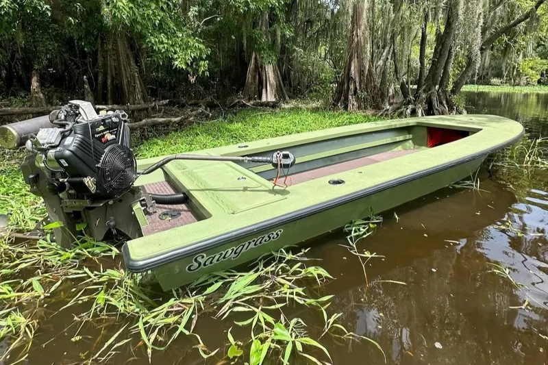 Slide: The Image of Sawgrass 17 boat, 2025 model, in a lush, swampy environment with dense greenery. - 2