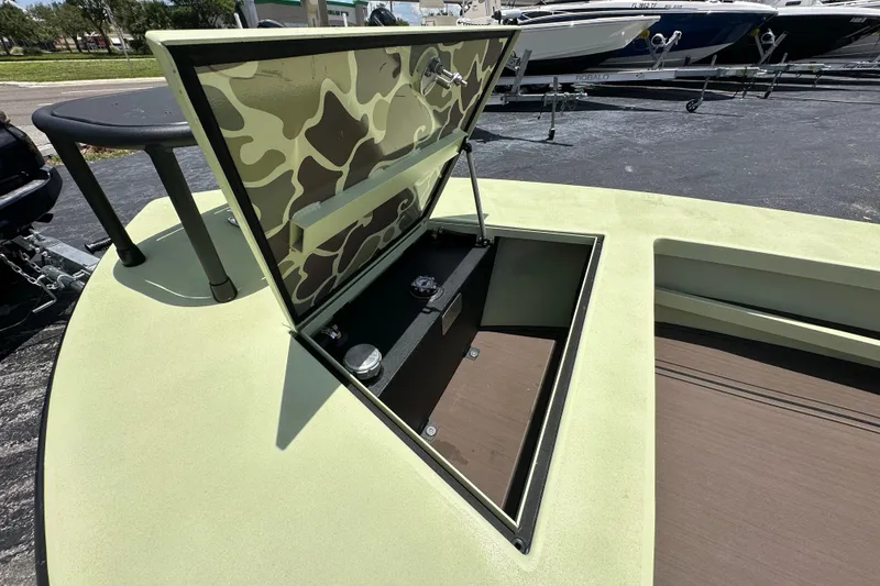 Slide: The Image of Open storage compartment on 2025 Sawgrass 17 boat with camouflage interior design. - 8