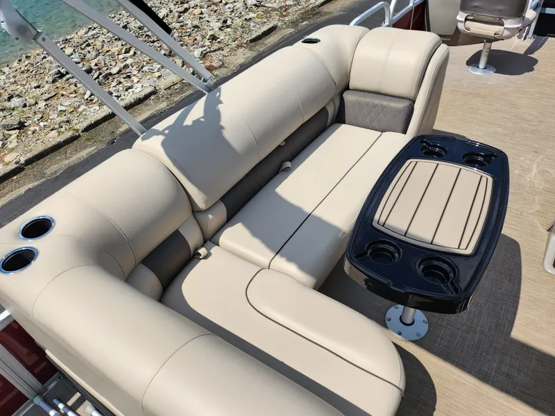 Slide: The Image of 2021 Sun Tracker Fishin' Barge 20 DLX interior with beige seating and table. - 24