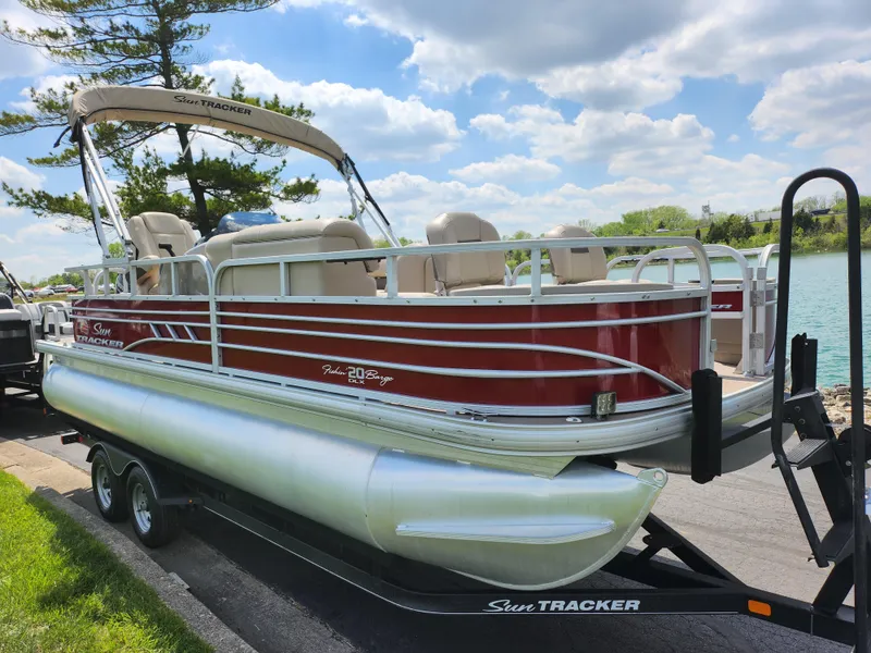 Slide: The Image of 2021 Sun Tracker Fishin' Barge 20 DLX pontoon boat on trailer by a lake. - 8