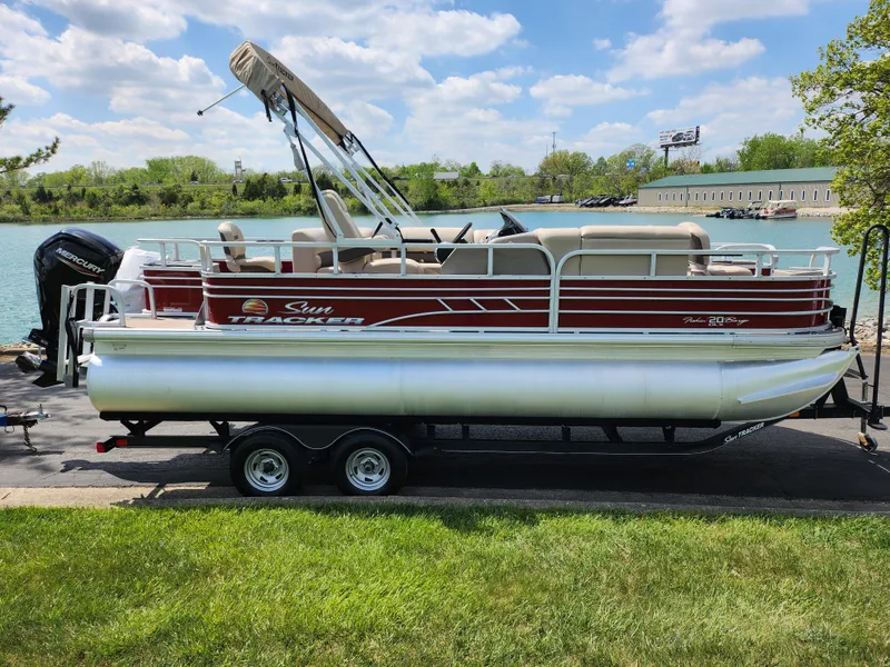 Slide: The Image of 2021 Sun Tracker Fishin' Barge 20 DLX pontoon boat on trailer by a lake. - 9