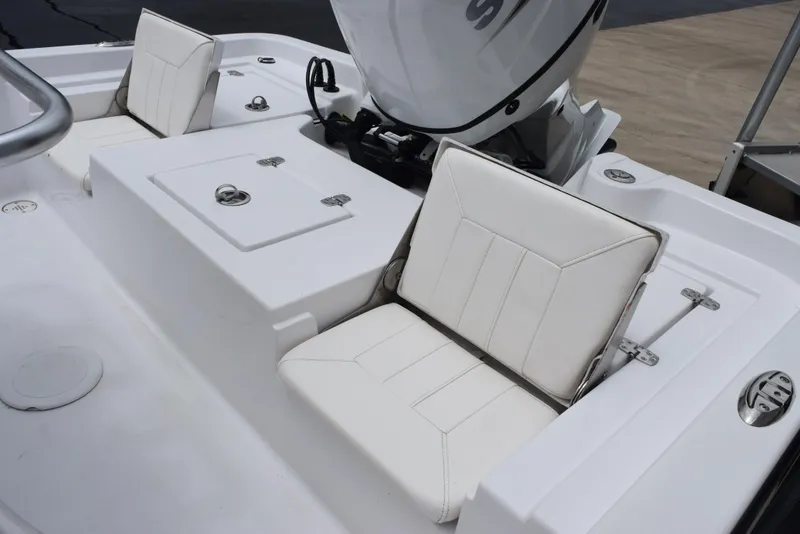 Slide: The Image of 2017 Blazer Bay 2200 boat interior with white cushioned seating and storage compartments. - 10