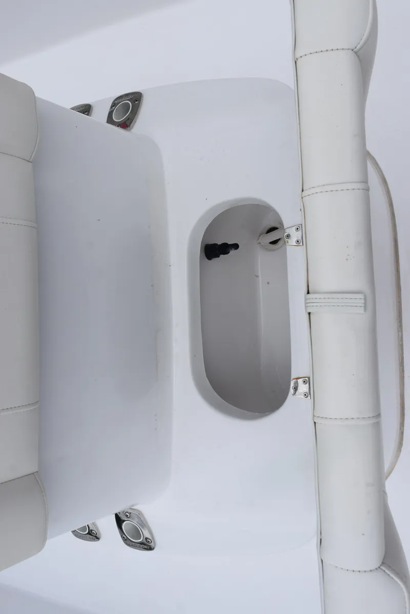 Slide: The Image of 2017 Blazer Bay 2200 boat interior with white seating and storage compartment. - 19
