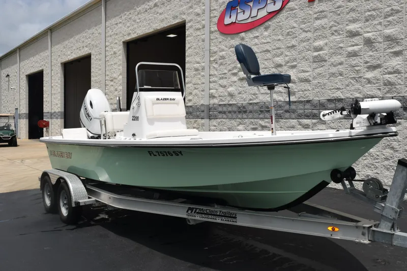 Slide: The Image of 2017 Blazer Bay 2200 boat on trailer outside dealership. - 2