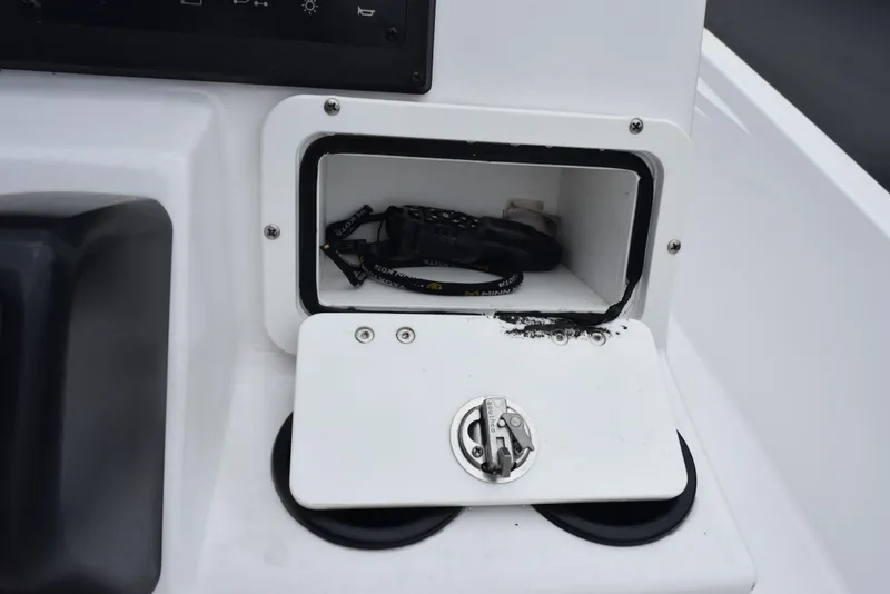 Slide: The Image of 2017 Blazer Bay 2200 boat compartment with open storage and visible cables. - 21