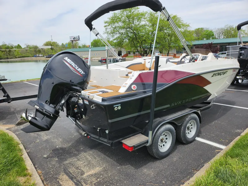 Slide: The Image of 2021 Starcraft SVX 191 OB boat on trailer with Mercury outboard motor in parking lot. - 1