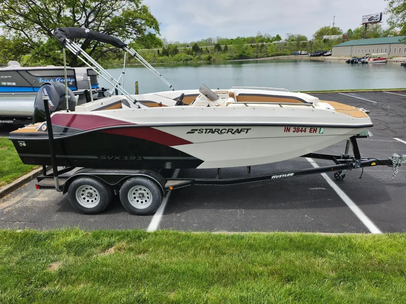 Slide: The Image of 2021 Starcraft SVX 191 OB boat on trailer by a lake. - 10