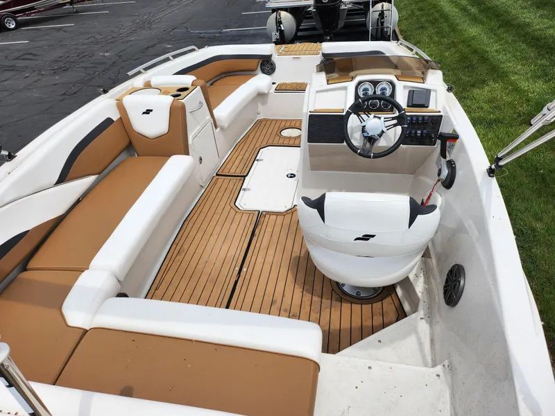 Slide: The Image of 2021 Starcraft SVX 191 OB boat interior with tan and white seating, steering console, and wood flooring. - 11