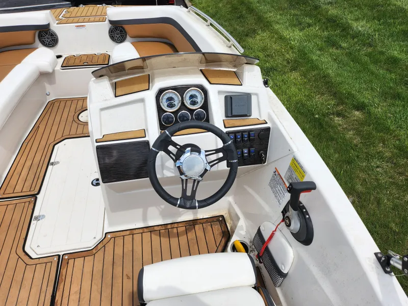 Slide: The Image of 2021 Starcraft SVX 191 OB boat cockpit with steering wheel and control panel. - 12