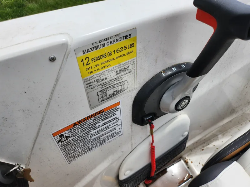 Slide: The Image of 2021 Starcraft SVX 191 OB boat capacity label and control lever detail. - 21