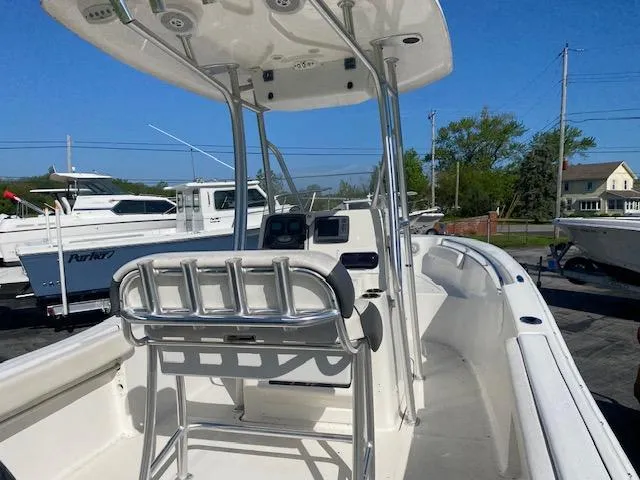 Slide: The Image of 2014 Tidewater 216 CC Adventure boat with T-top and console, docked outdoors. - 11