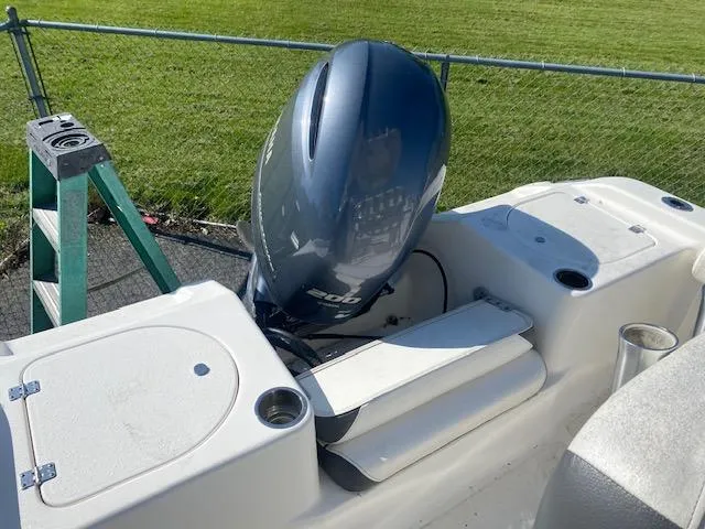 Slide: The Image of 2014 Tidewater 216 CC Adventure boat with outboard motor, parked near a grassy area. - 12