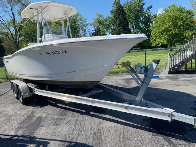 Slide: The Image of 2014 Tidewater 216 CC Adventure boat on trailer, parked outdoors. - 2