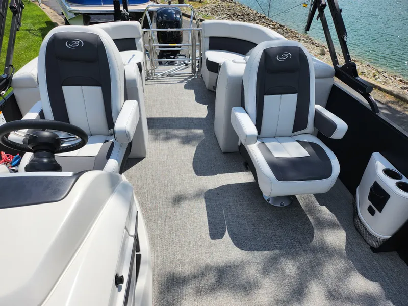 Slide: The Image of 2021 Barletta CORSA 23QC pontoon boat interior with plush seating and steering wheel. - 12