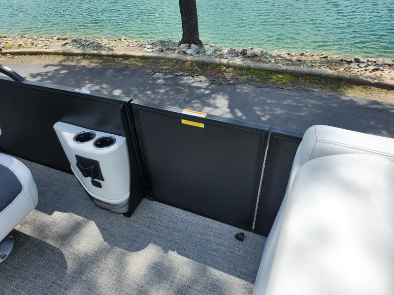 Slide: The Image of 2021 Barletta CORSA 23QC boat interior with cup holders, near a lakeside. - 13