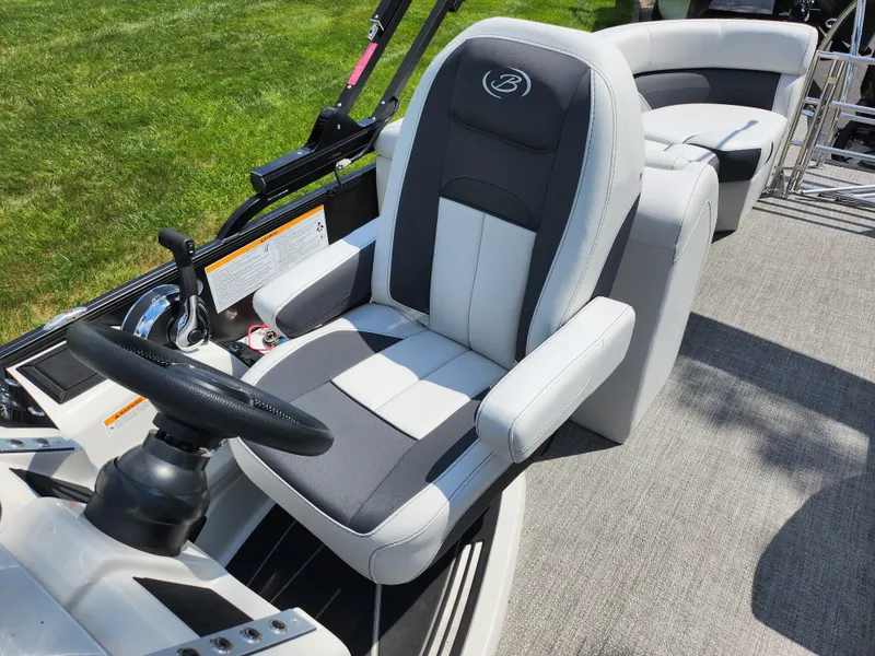 Slide: The Image of 2021 Barletta CORSA 23QC boat interior with plush captain's chair and steering wheel. - 14